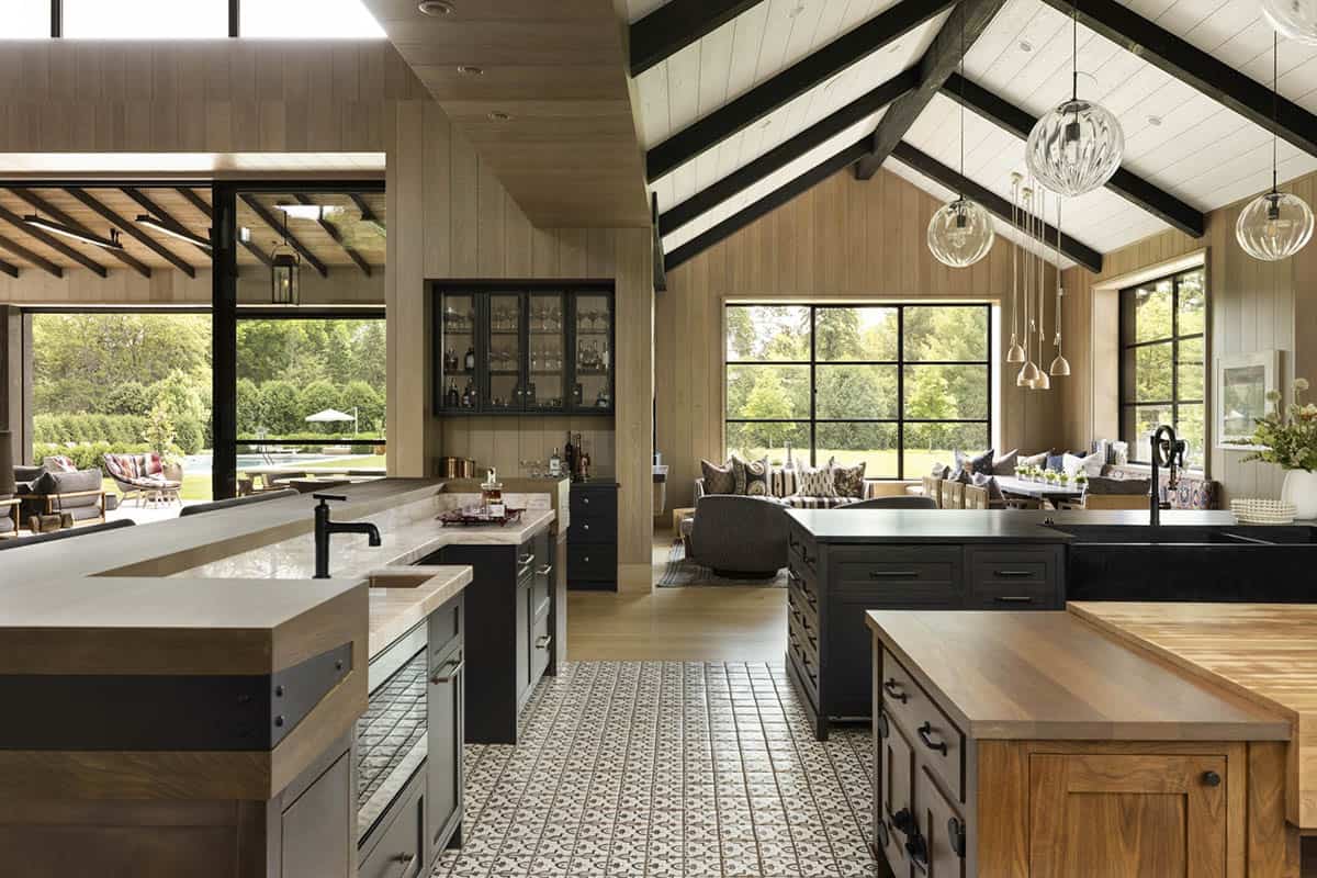 Open kitchen and living area with vaulted beamed ceiling, patterned floor tile, and pool visible through sliding doors