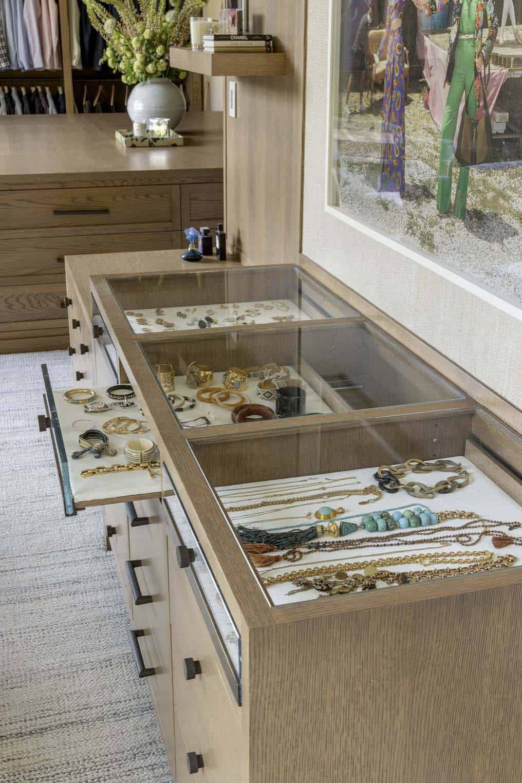 Open jewelry drawer detail showing rings and bracelets arranged on velvet-lined trays