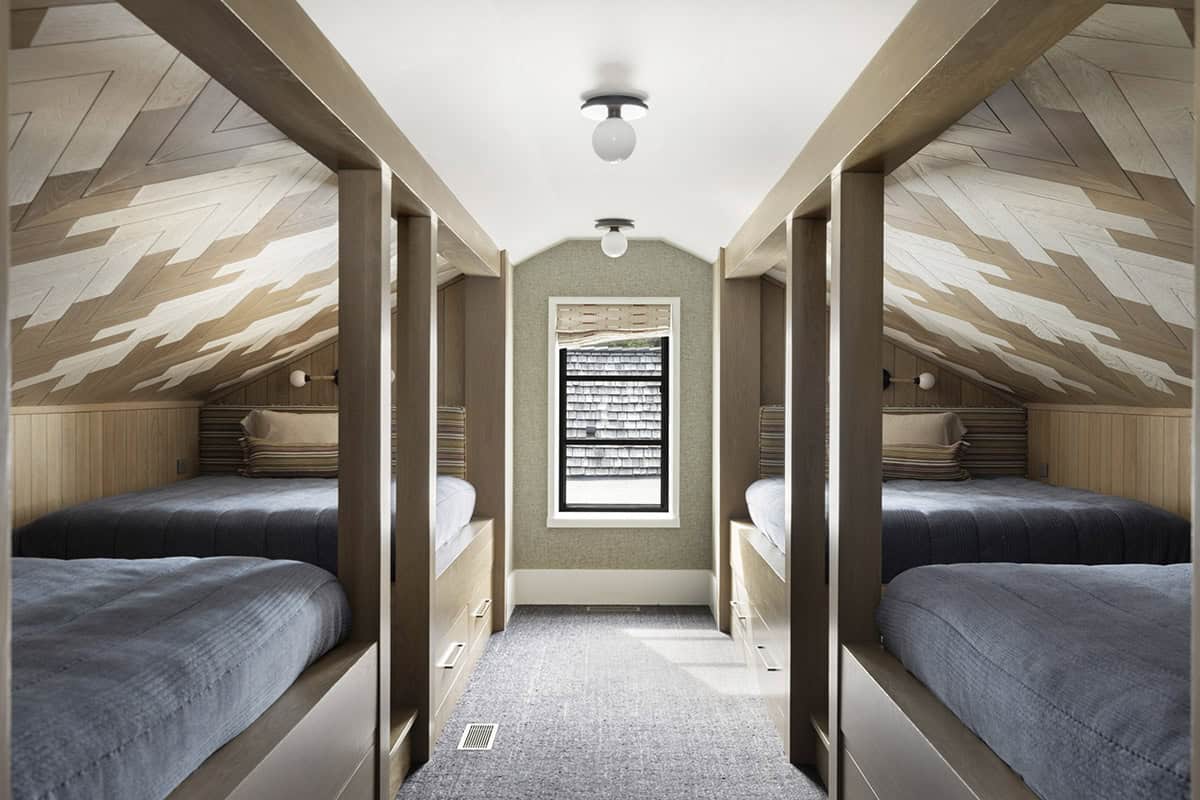 Bunk room with angled patterned wood ceiling, built-in beds, and dormer window
