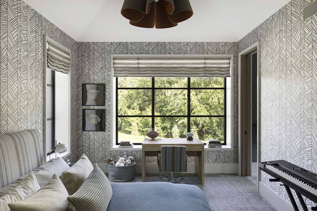 Kid's bedroom with graphic wallpaper, window-side desk, and dog-themed wall art
