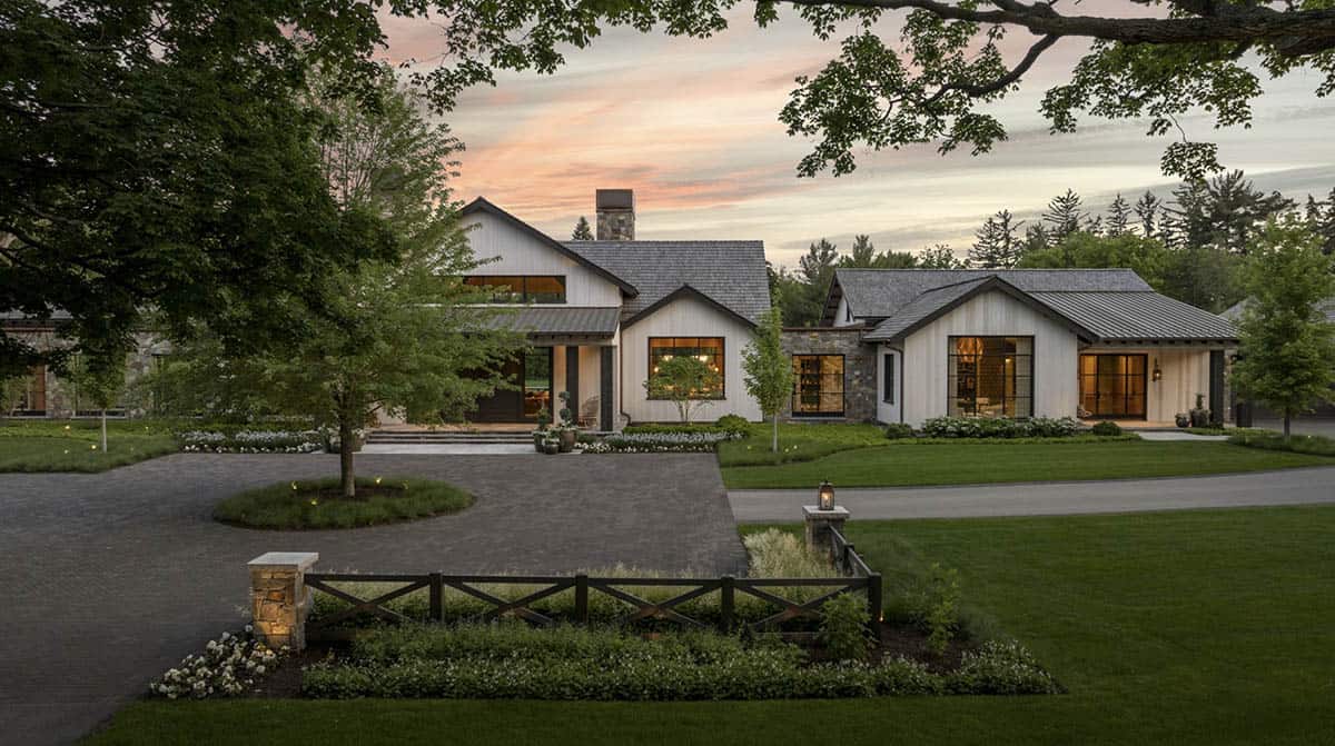 Front exterior at dusk with illuminated windows, gabled rooflines, and circular motor court