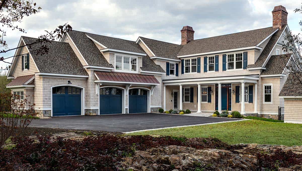Oceanfront shingle-style Colonial home with navy garage doors and copper roof accents