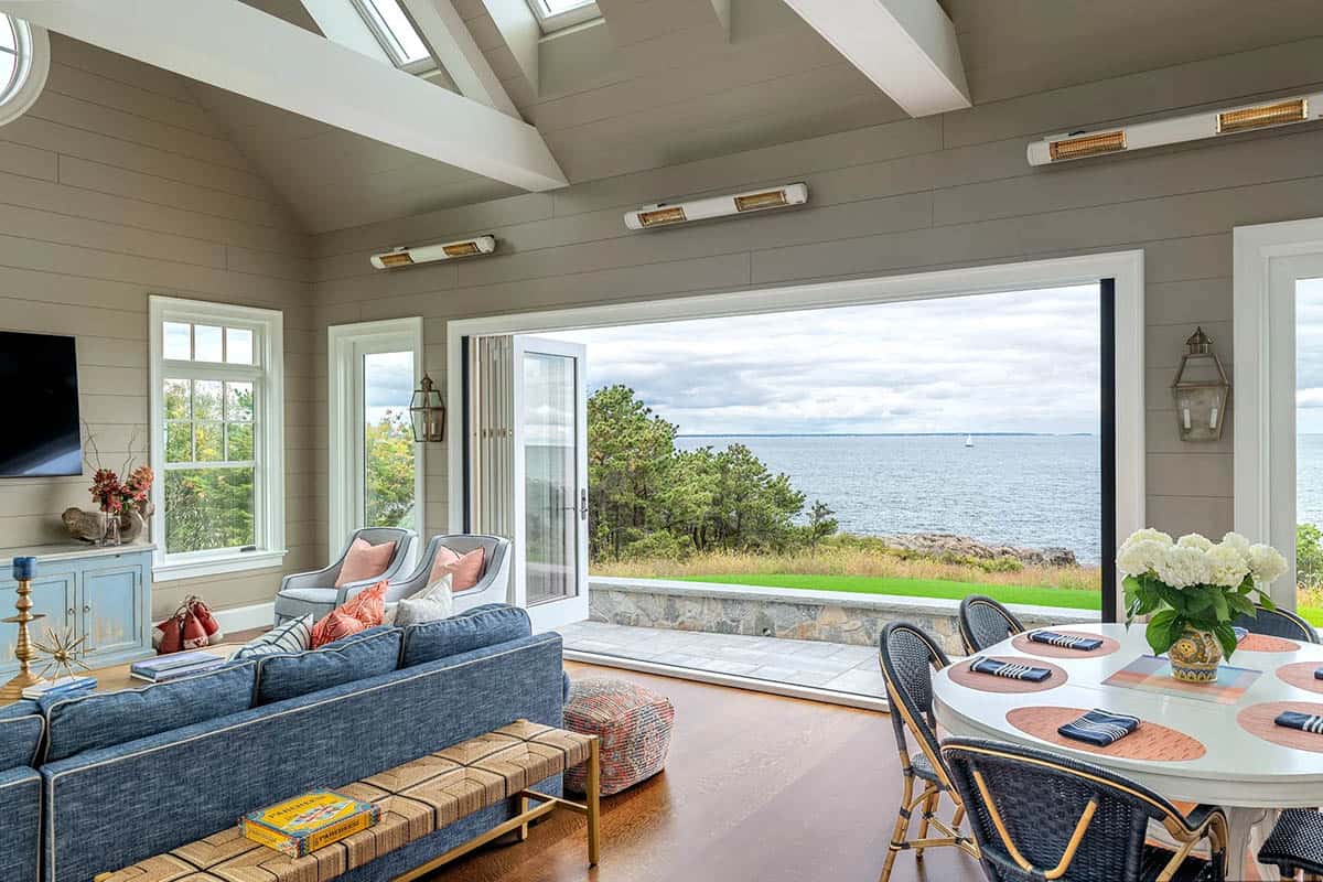 Sunroom with folding glass doors opening to ocean view and dining table