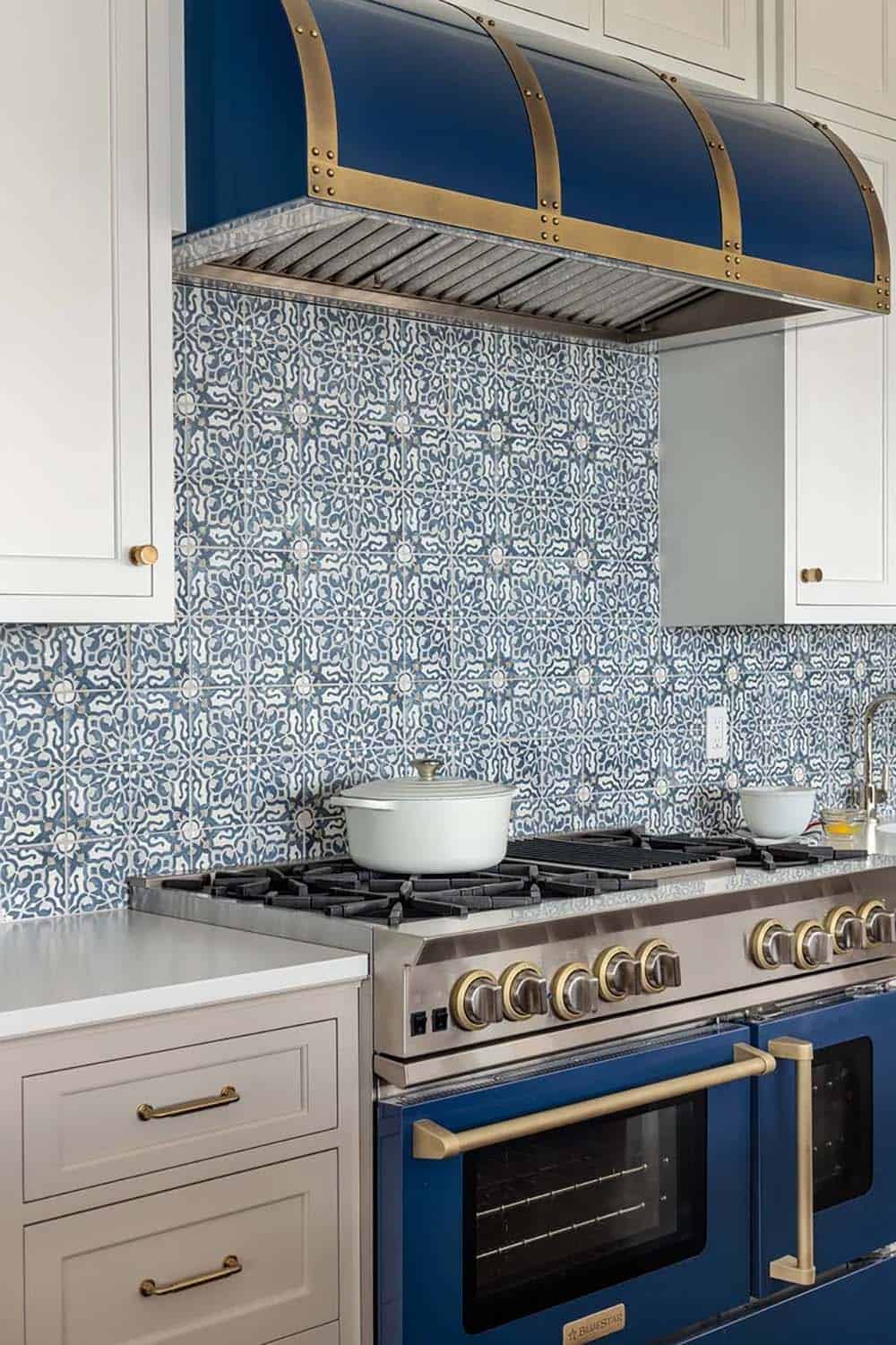 Kitchen range with navy hood and blue-and-white patterned tile backsplash