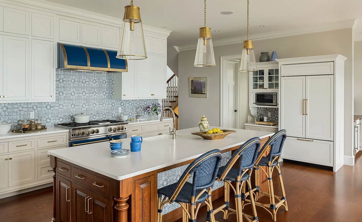 Kitchen with wood island, navy stove, and brass pendant lights