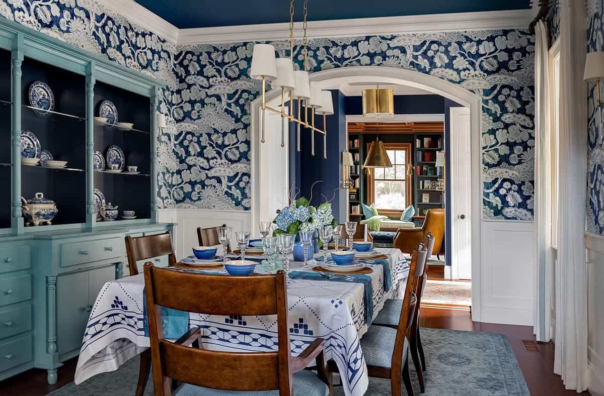 Dining room with navy blue-and-white botanical wallpaper and teal hutch