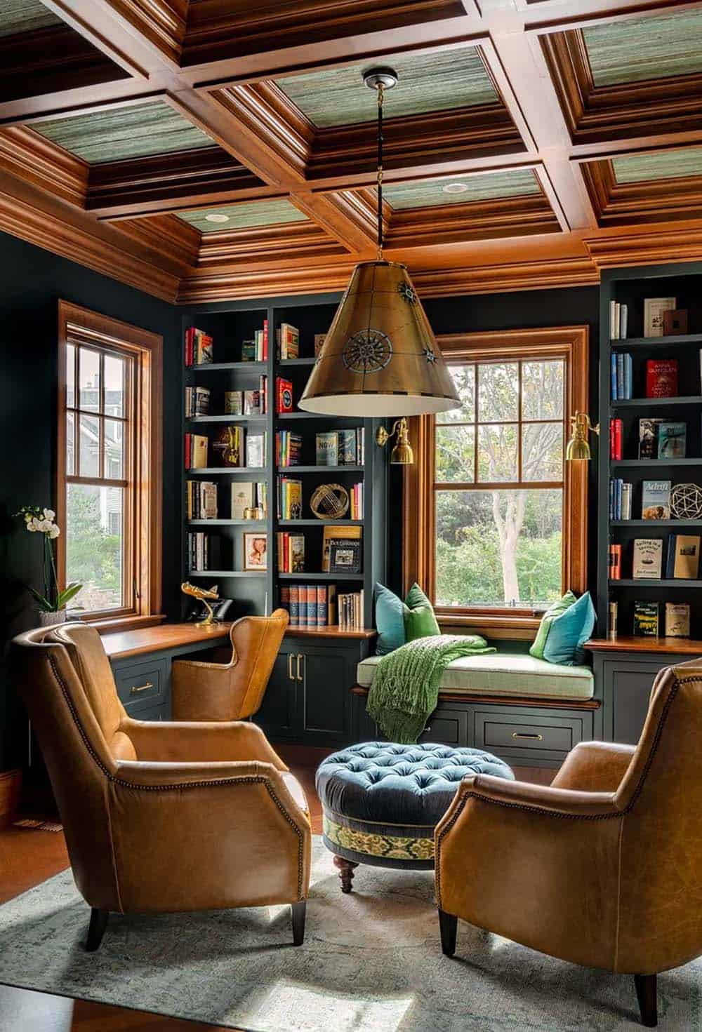 Wood-paneled study with coffered ceiling, leather chairs, and window seat