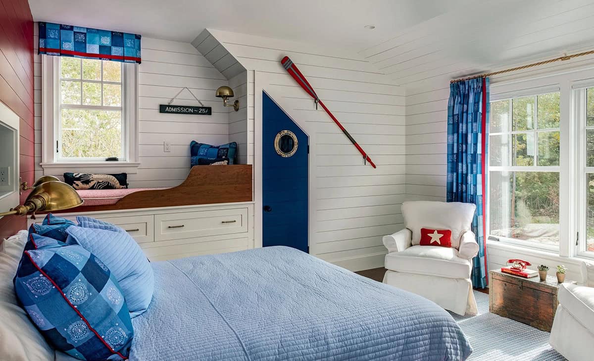 Nautical-themed kids' room with red oar, porthole door, and blue curtains
