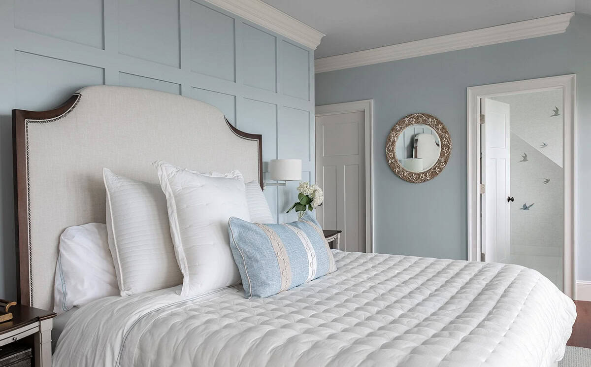 Primary bedroom with upholstered headboard and blue paneled accent wall