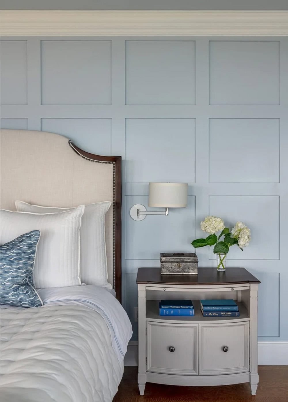 Bedside table detail against blue wainscoted wall with hydrangeas