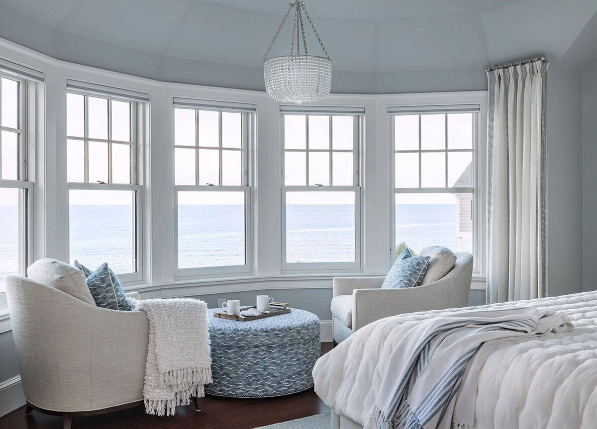 Curved bay window bedroom sitting area with ocean view and chandelier
