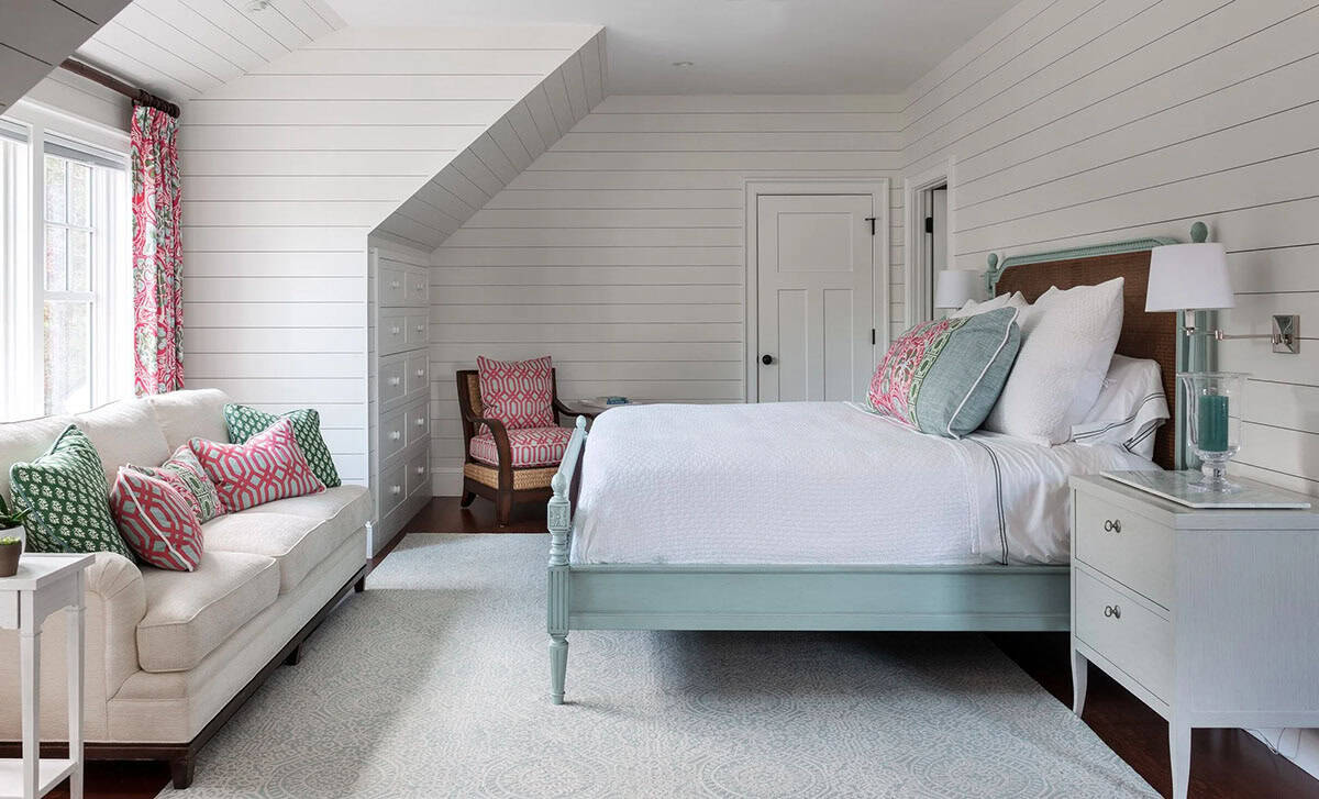 Bedroom with pale blue shiplap walls and coral-patterned accents