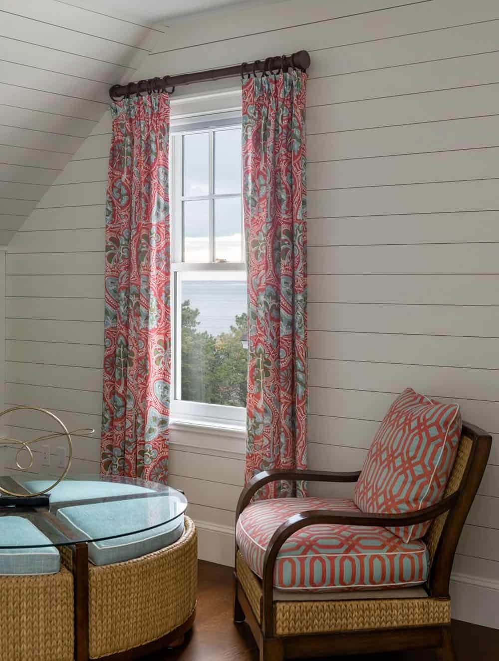 Reading nook with coral geometric curtains and woven rattan chair