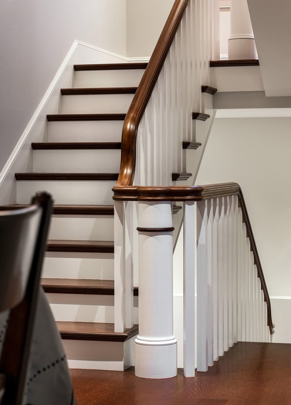 Staircase detail with dark wood handrail and white balusters