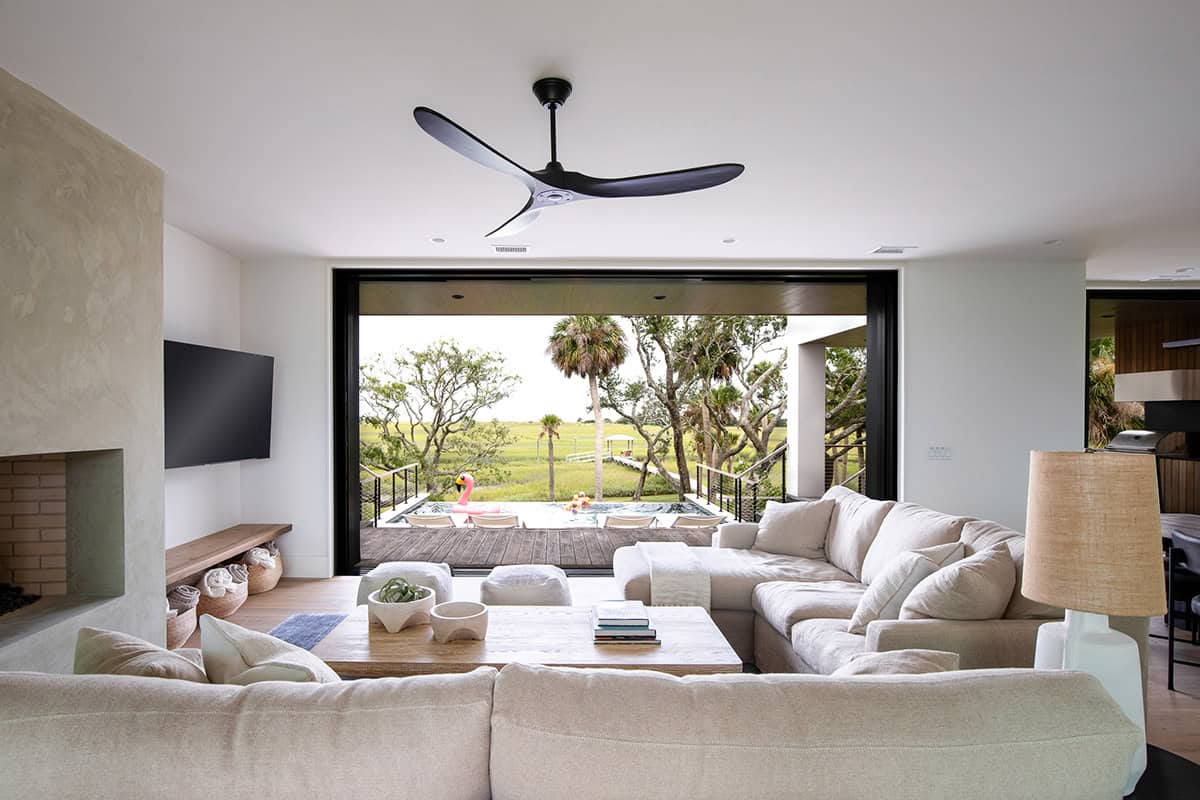 Living room with sectional sofa facing open sliding doors to pool deck