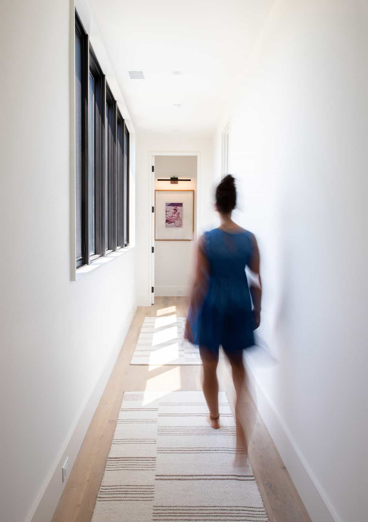 Bright hallway with striped runner rugs and framed beach artwork