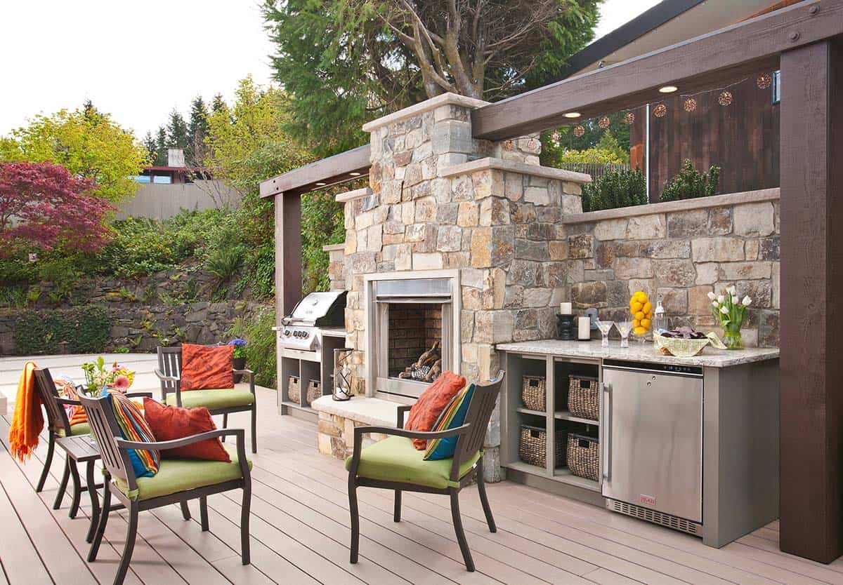 Deck outdoor kitchen with Montana Glacier stone fireplace, built-in grill, and mini fridge in Lakewood, Washington