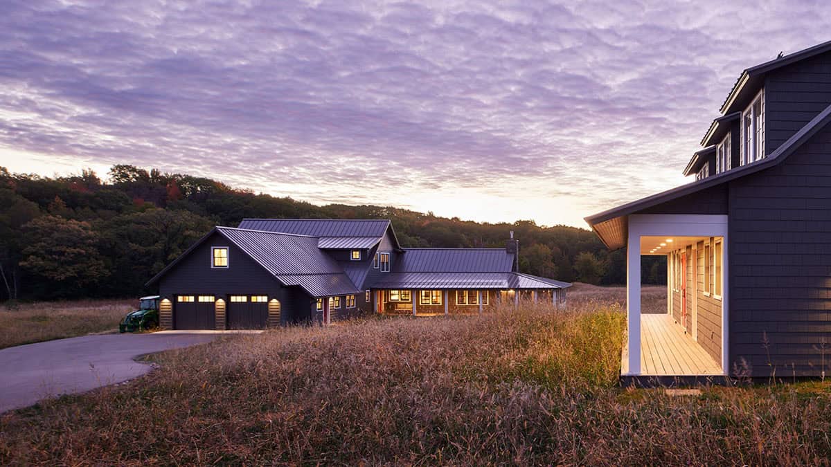 Aerial-level view of house complex at twilight with garage, main house, and lit breezeway