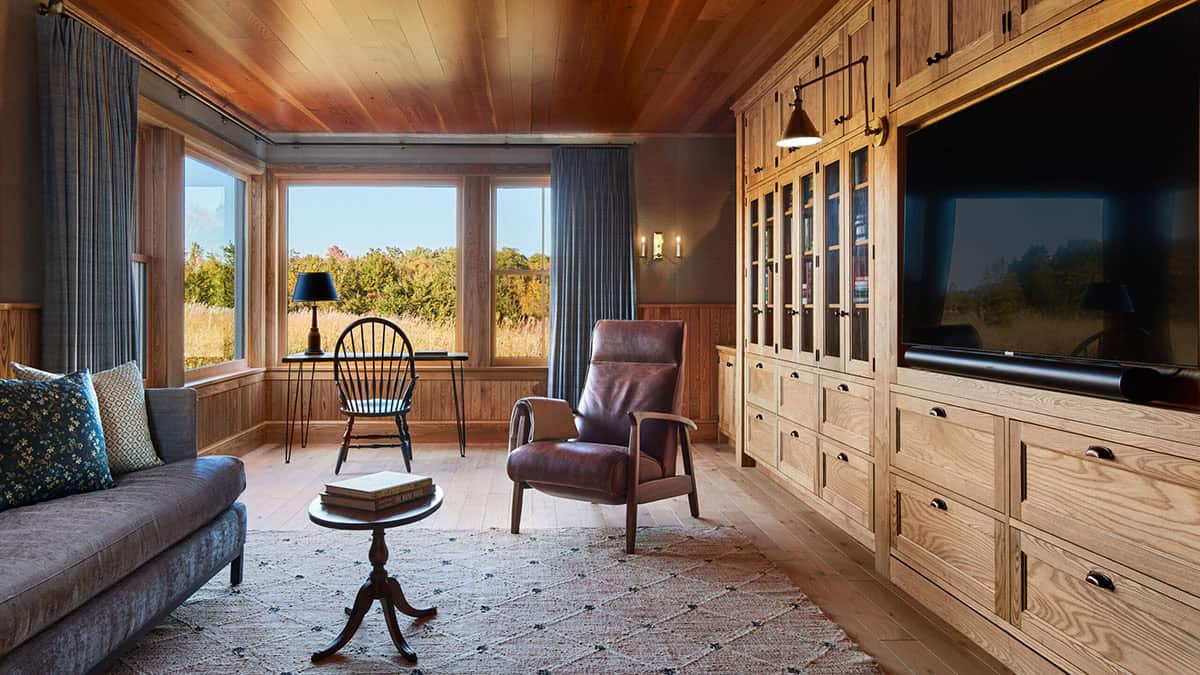 Cozy den with wood plank ceiling, built-in oak cabinetry, and a window desk nook
