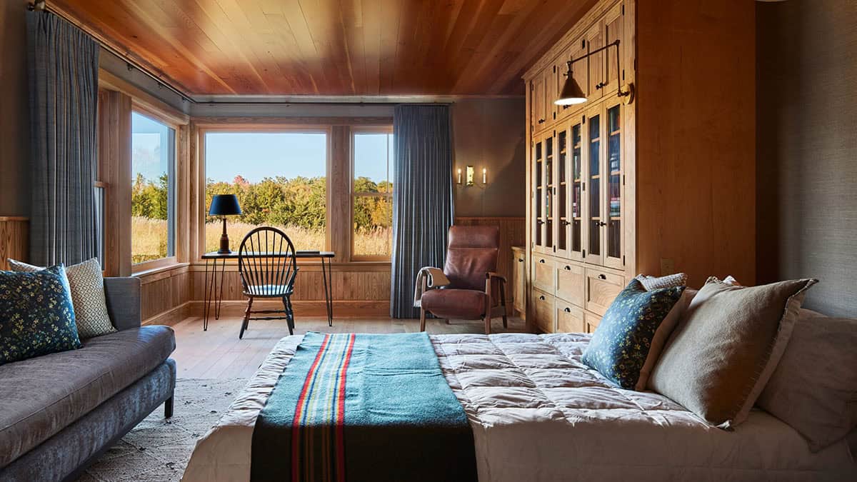 Bedroom with wood plank ceiling, built-in cabinetry, and striped wool blanket