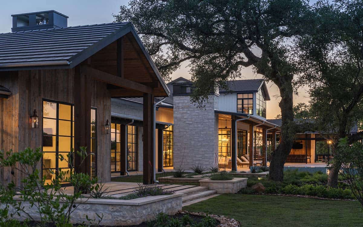Dusk view of covered walkway connecting stone and wood-clad wings