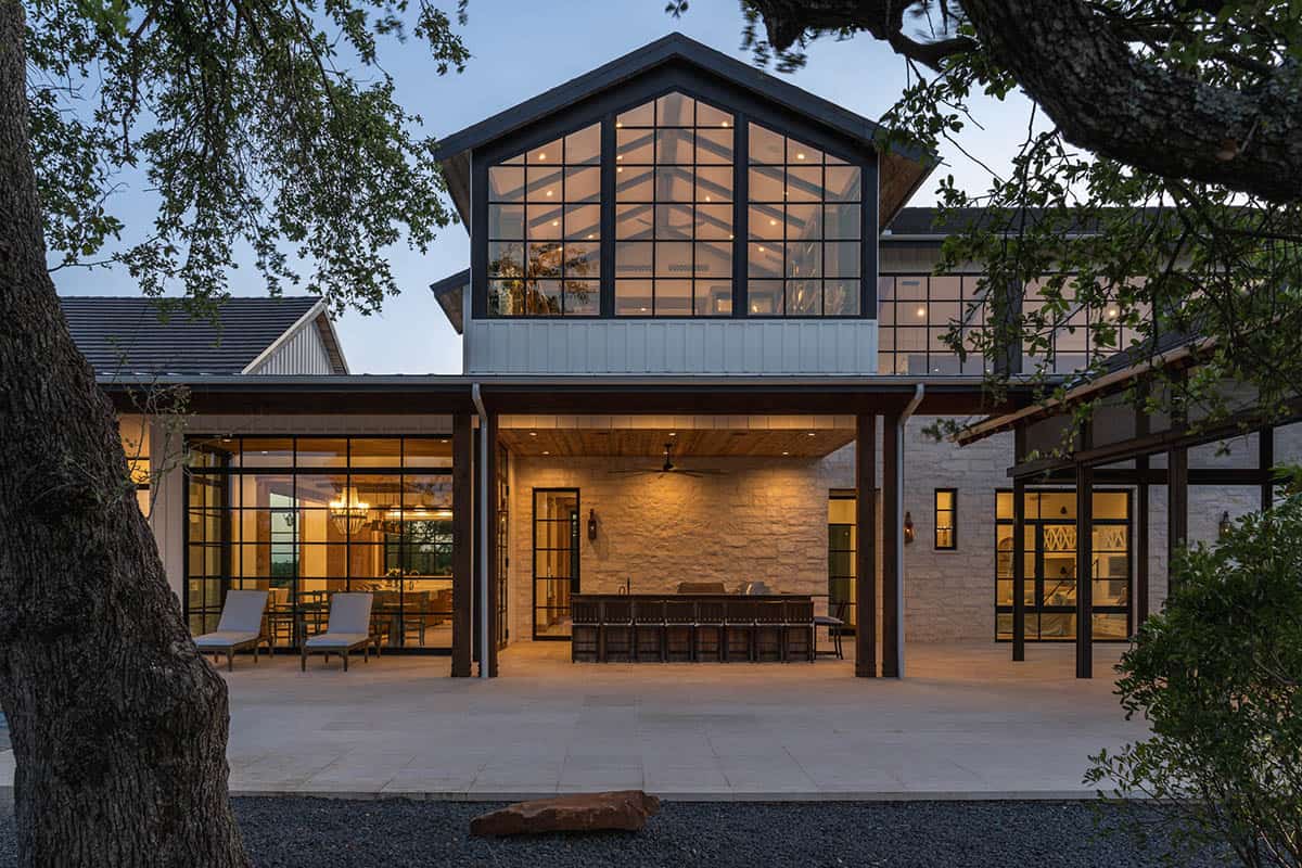 Two-story great room with glass gable and stone outdoor kitchen