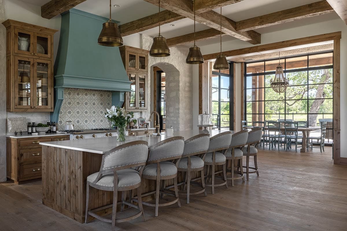 Kitchen island with teal range hood and patterned tile backsplash
