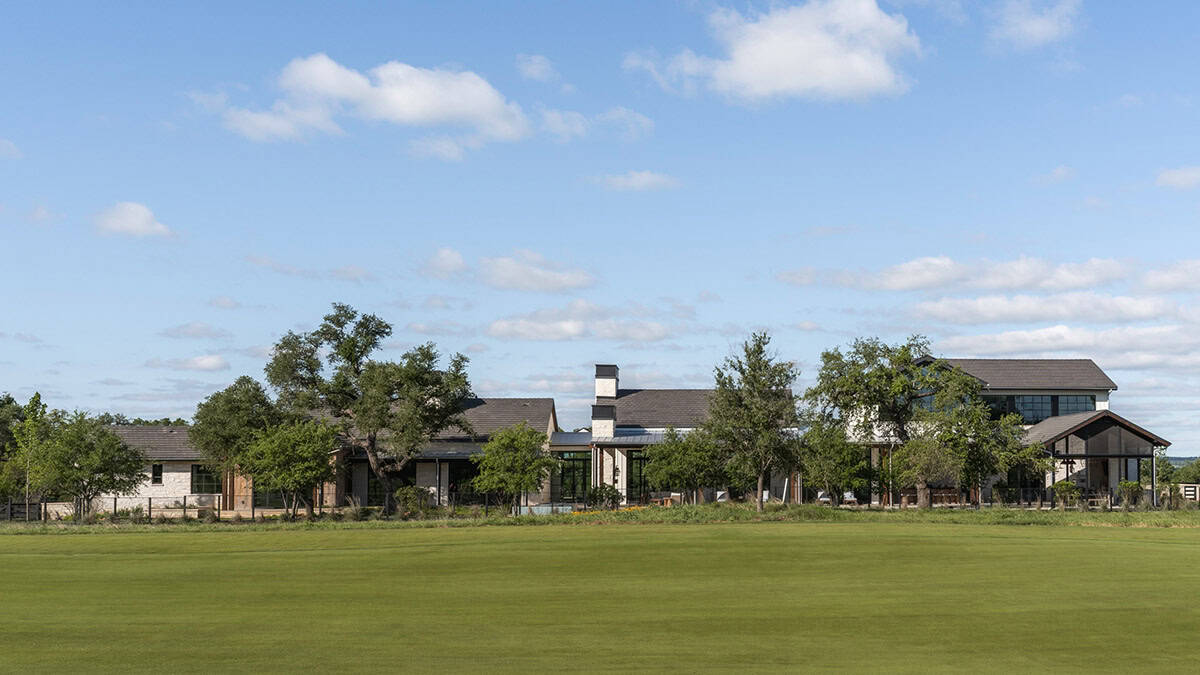 Wide view of the ranch home from across the open pasture