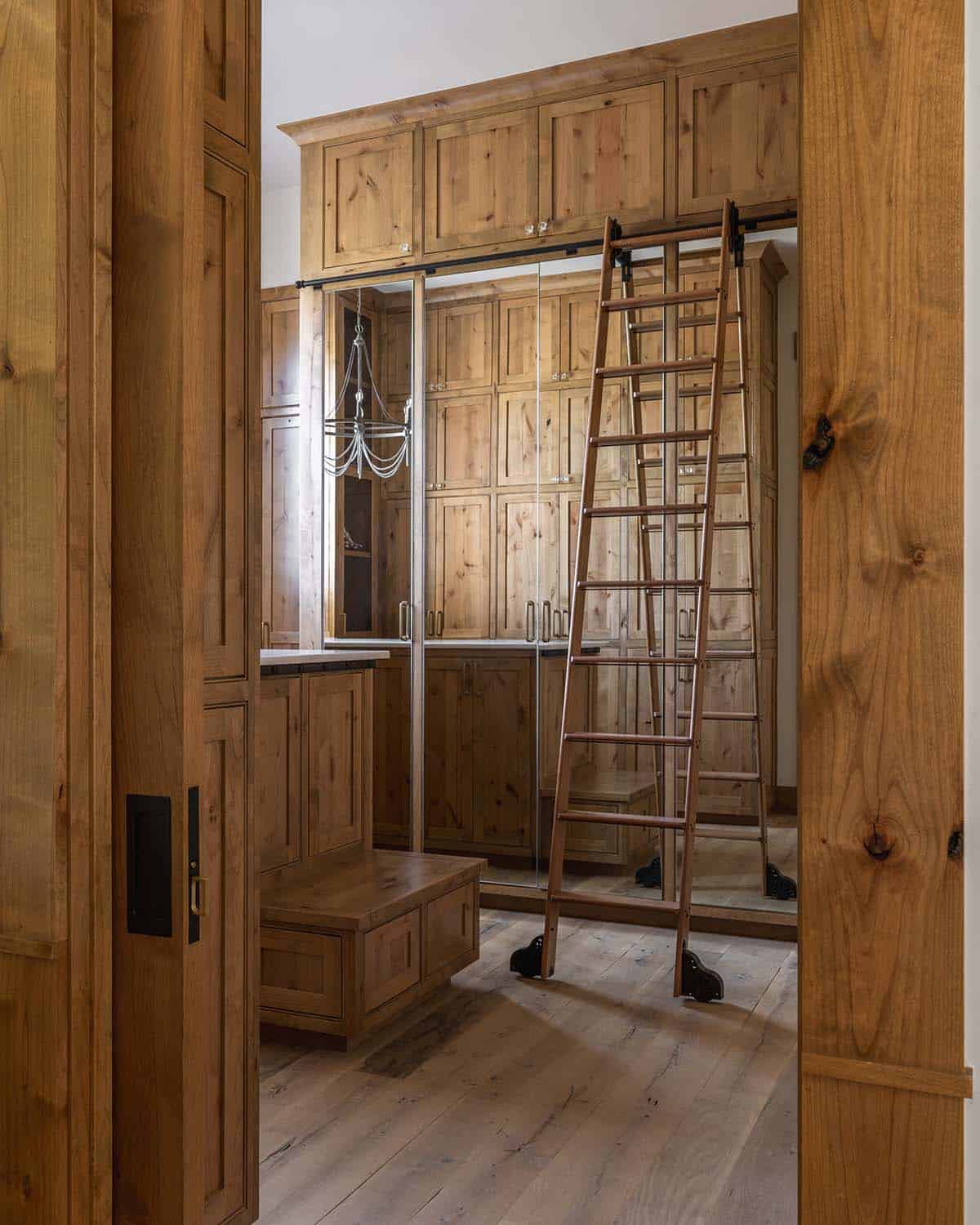 Walk-in closet with built-in cabinetry, rolling ladder, and mirrored doors