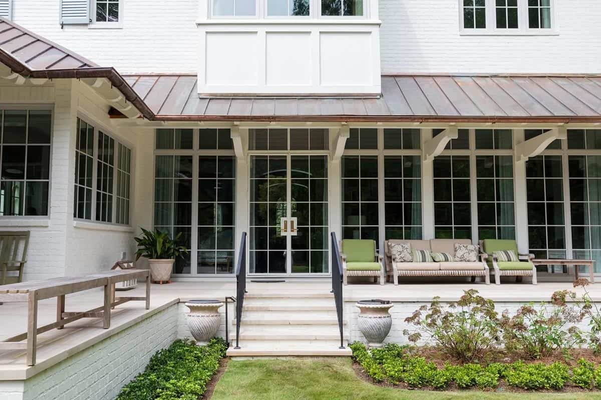 Rear patio with screened porch, copper roof, and green-cushioned outdoor seating
