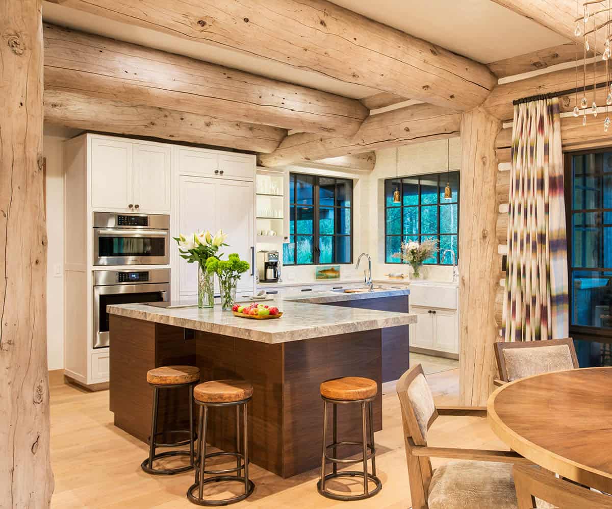 Kitchen with log posts, marble island, and bar stools