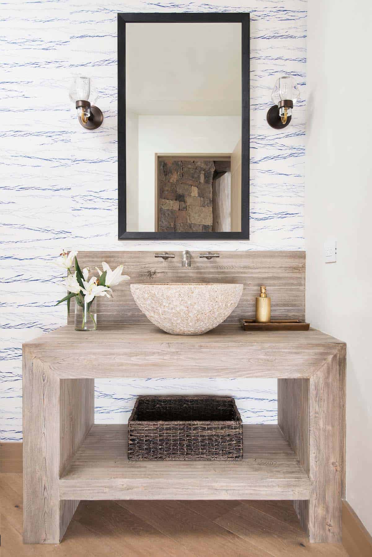 Powder room with stone vessel sink and patterned wallpaper