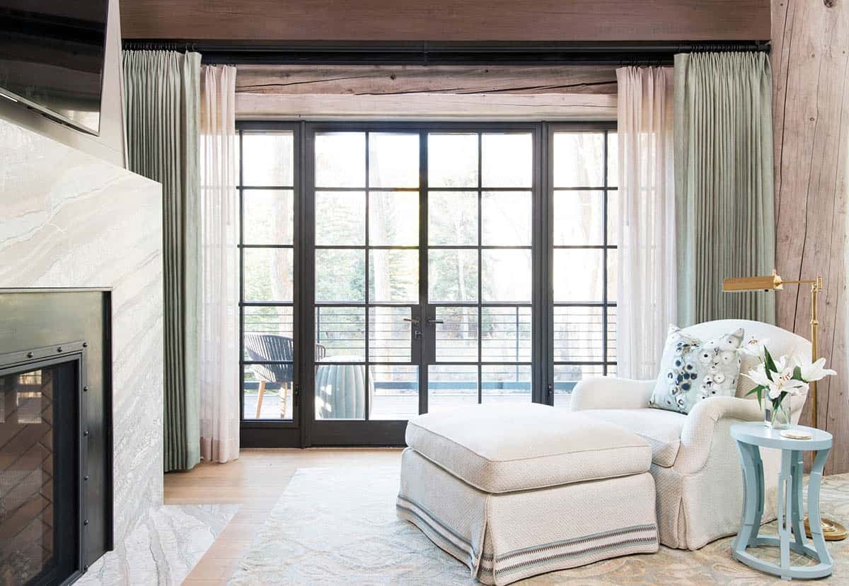 Bedroom seating nook with fireplace and floor-to-ceiling glass doors