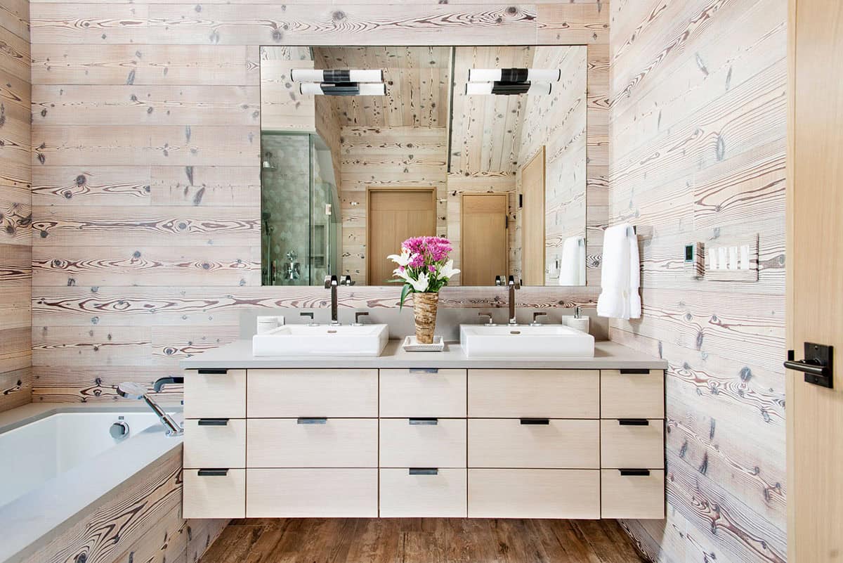 Bathroom with double vessel sinks and whitewashed wood-plank walls