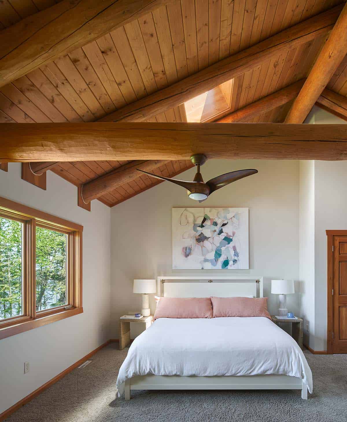 Bedroom with vaulted wood ceiling, exposed beams, and abstract art above the bed