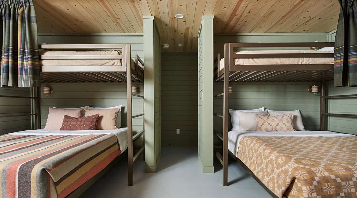 Bunk room with two sets of built-in bunk beds in sage green paneling