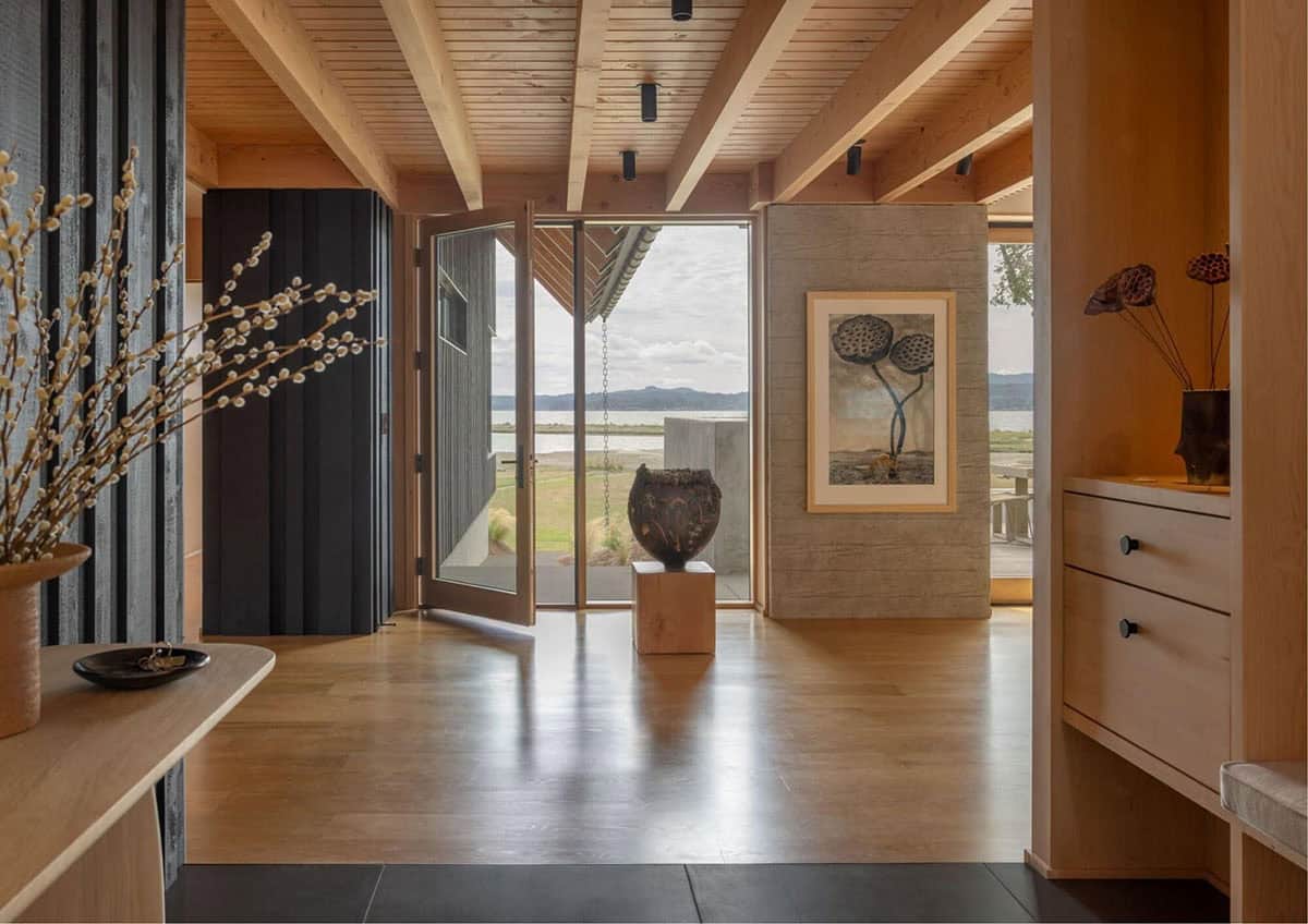Wood-beamed entry foyer with sliding door open to water view