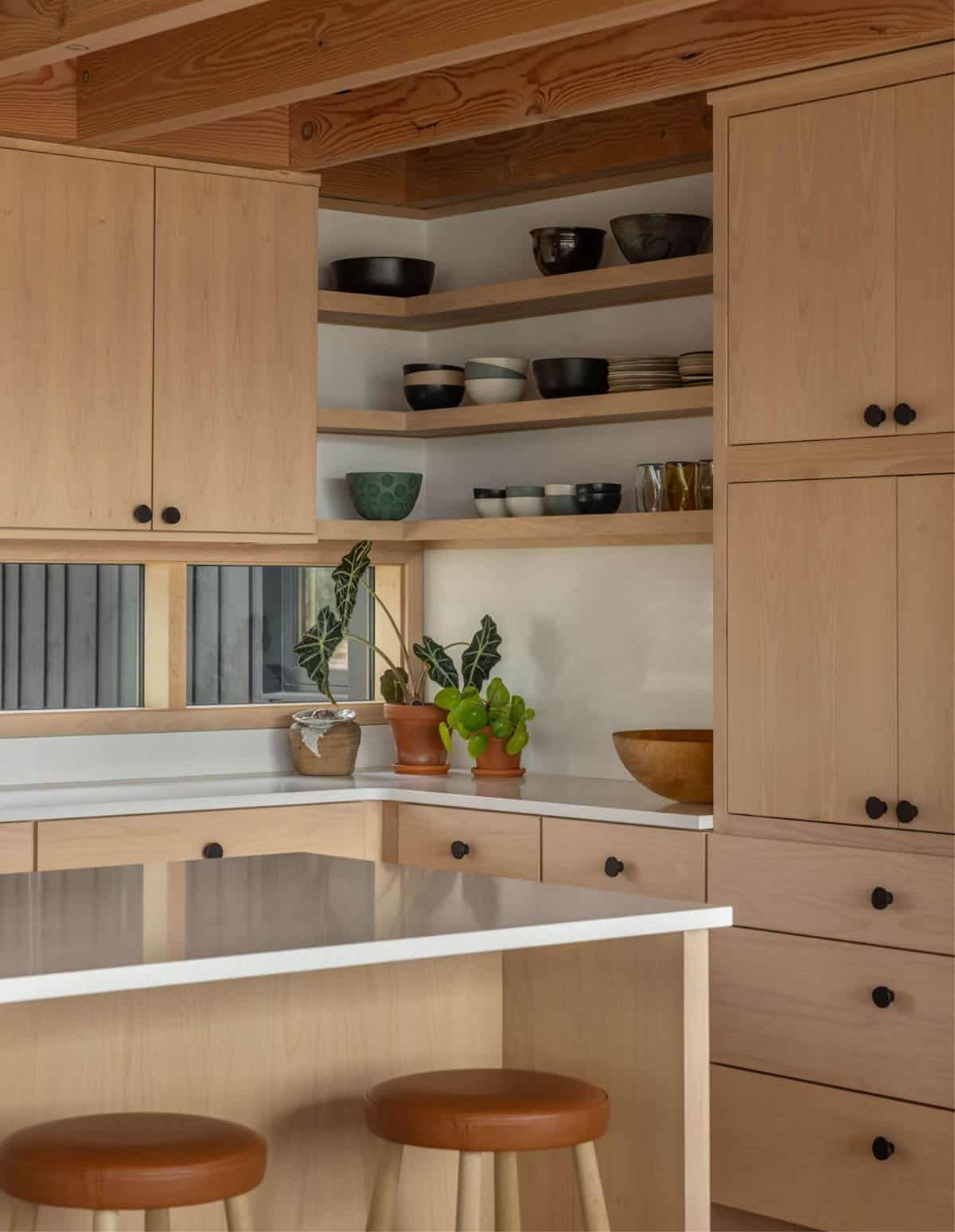 Kitchen corner shelving with ceramic bowls and potted plants