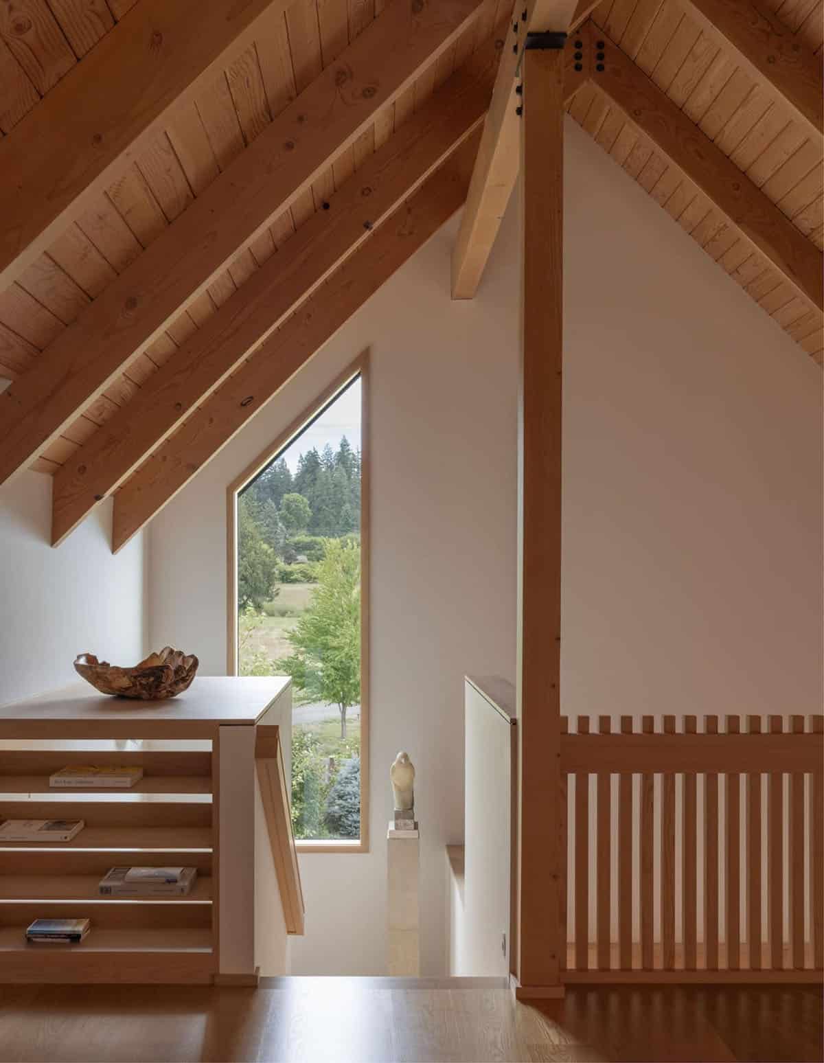 Attic landing with built-in shelving and tall angled window