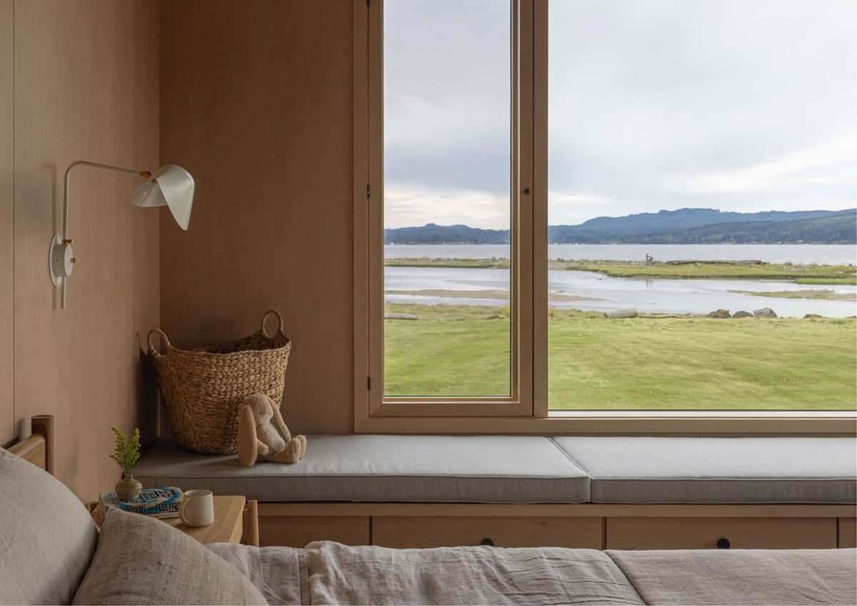 Bedroom window seat with woven basket overlooking inlet and mountains