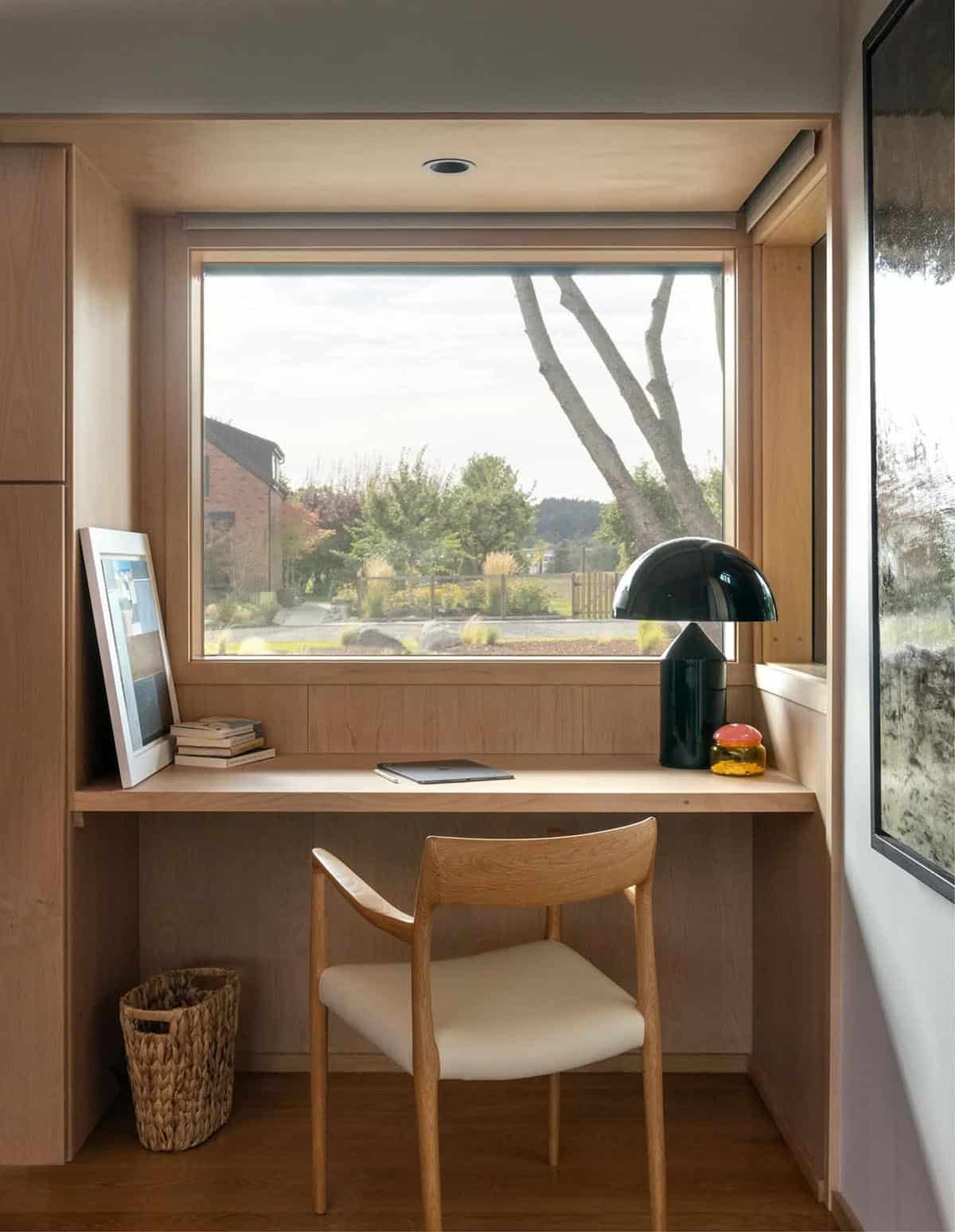 Built-in home office desk nook with wooden chair and large window