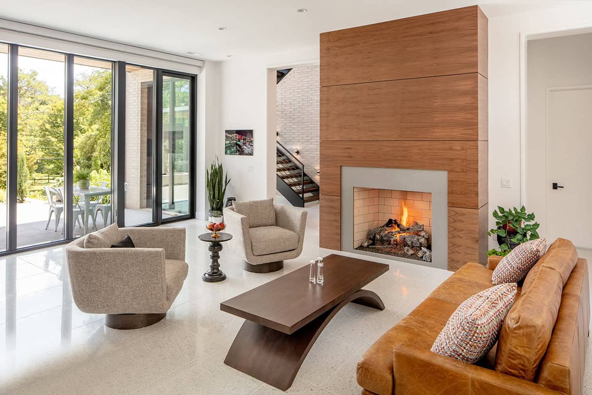Living room with wood-clad fireplace, leather sofa, and sliding glass doors to patio