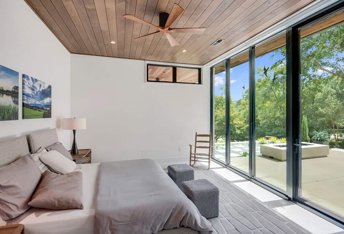 Bedroom with wood plank ceiling, ceiling fan, and floor-to-ceiling sliding doors to terrace