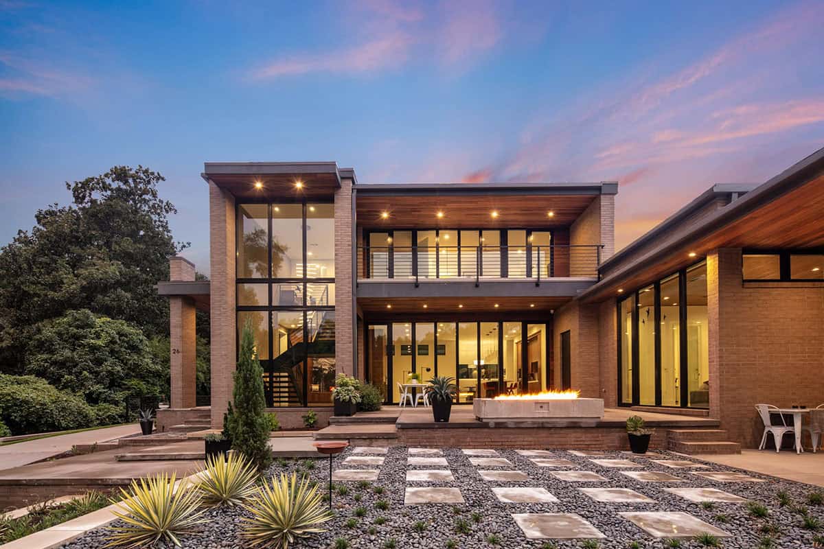 Straight-on twilight shot of the home's rear elevation with fire feature