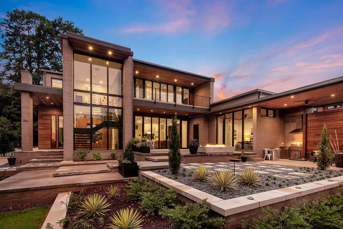 Wide twilight exterior view showing full home layout with fire pit and landscaping