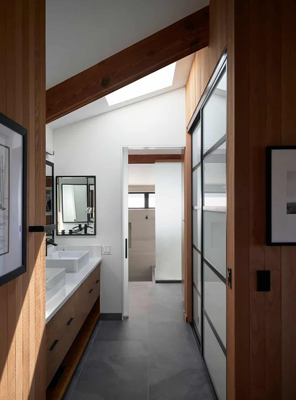 Primary suite bathroom with frosted glass sliding doors and slate flooring