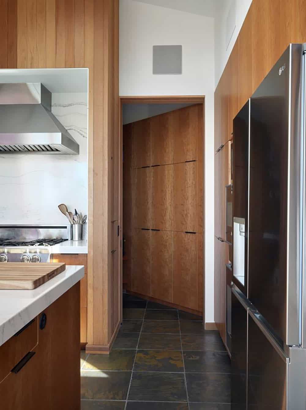 Kitchen pantry hallway with slate floor and built-in refrigerator