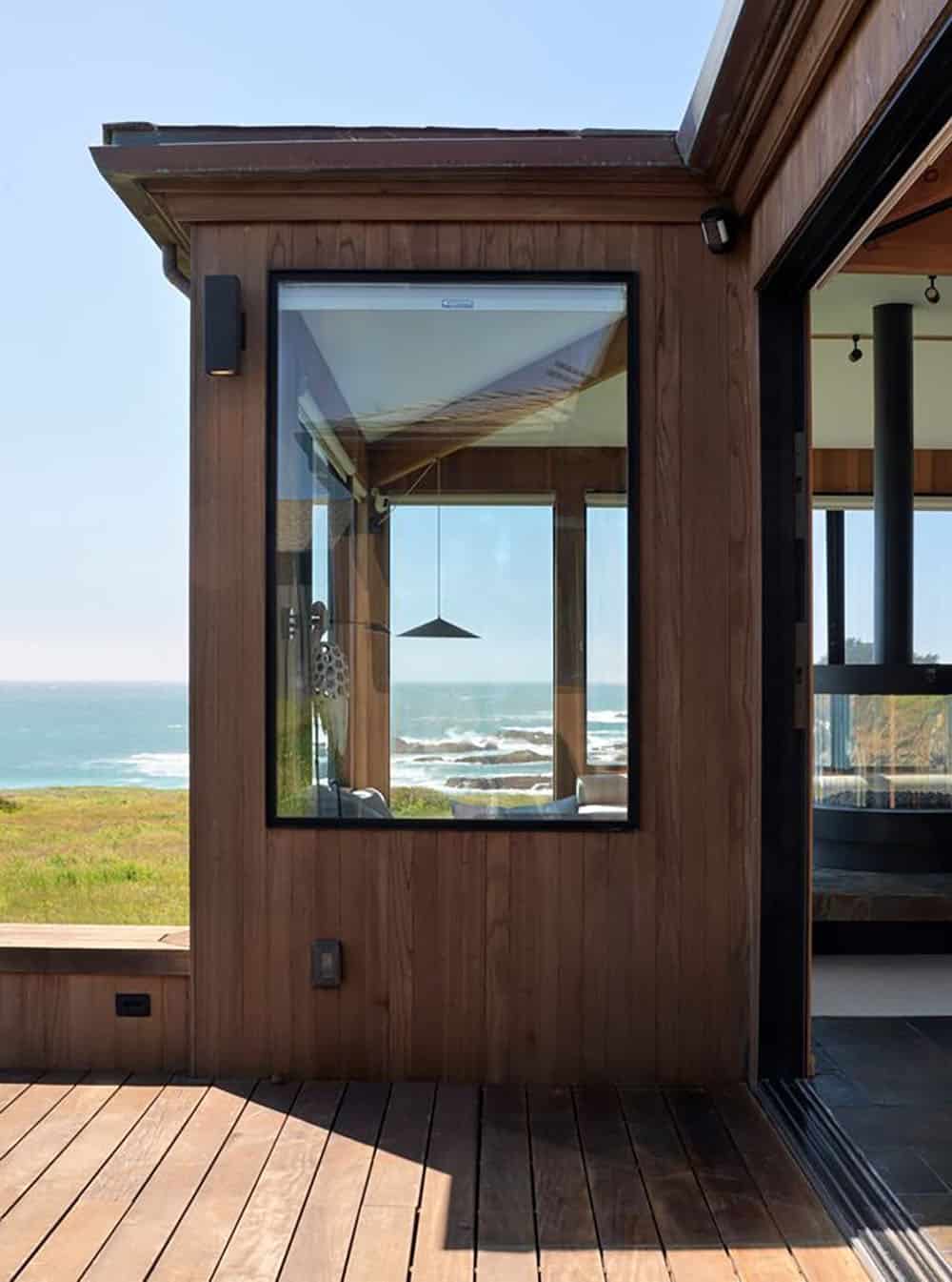 Exterior window reflecting ocean view beside open sliding door