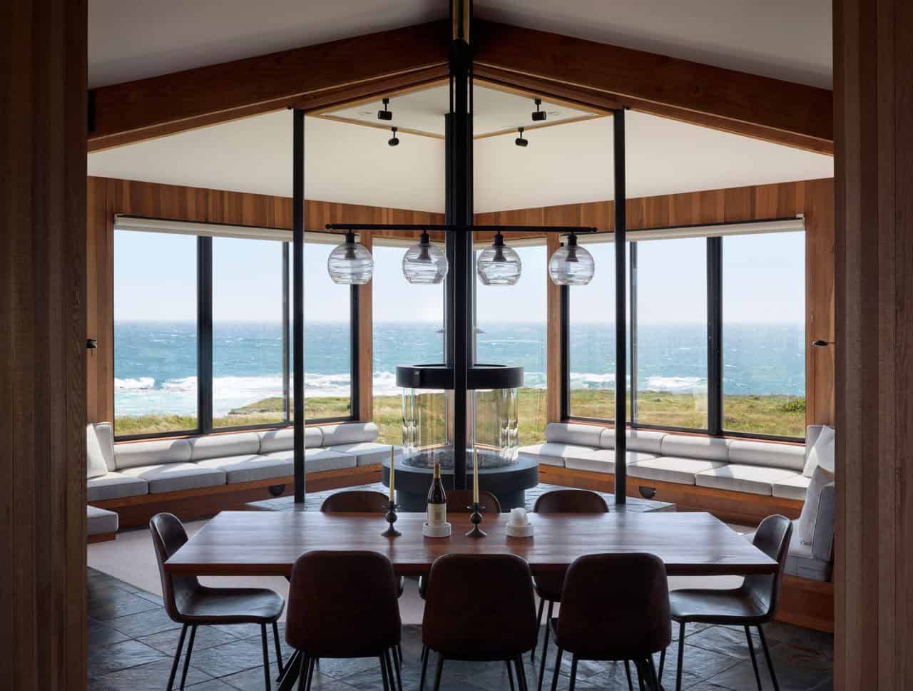Dining room with cylindrical fireplace and panoramic ocean windows