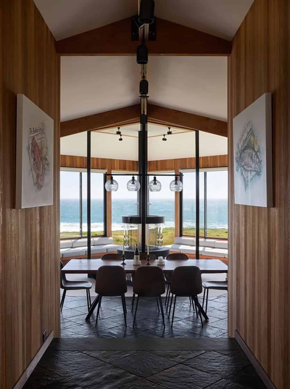 Hallway view into dining room framed by artwork and ocean windows